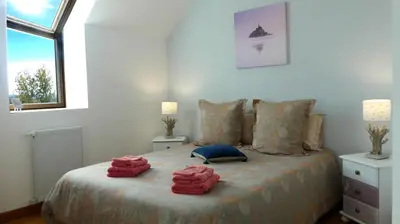Un ou plusieurs lits dans un hébergement de l'établissement REVES DE BAIE - Chambre d'hôtes COSY avec table BIO et MASSAGES - Vue panoramique exceptionnelle