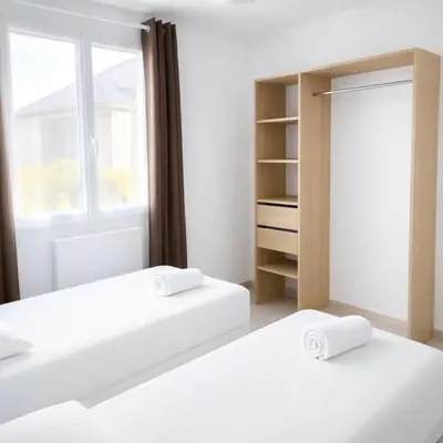 Un ou plusieurs lits dans un hébergement de l'établissement Maison Cosy proche Plage - Cour & Parkings
