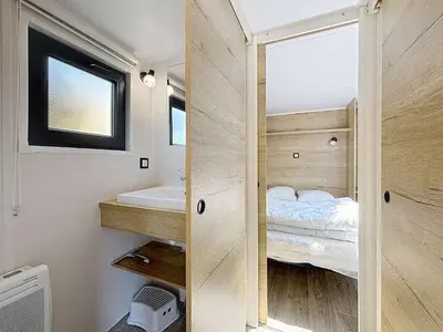 Un ou plusieurs lits dans un hébergement de l'établissement Tiny House bois avec terrasse, piscine, wifi, animaux admis, parking - 200m de la plage - FR-1-361A-88
