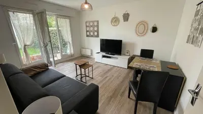 Télévision ou salle de divertissement dans l'établissement Studio avec jardin centre ville Cabourg La Roseraie