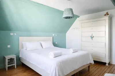 Un ou plusieurs lits dans un hébergement de l'établissement Maison spacieuse au coeur du Centre - Plage à pied