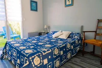 Un ou plusieurs lits dans un hébergement de l'établissement Appartement avec jardin et plage