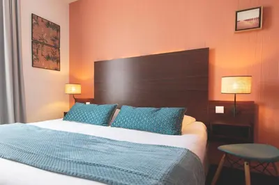 Un ou plusieurs lits dans un hébergement de l'établissement Hôtel Les Coutainvillaises