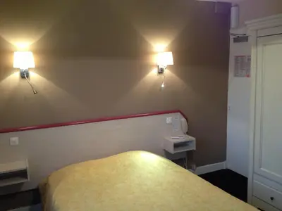 Un ou plusieurs lits dans un hébergement de l'établissement Hôtel La Champagne Ardenne Cabourg