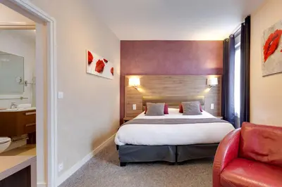 Un ou plusieurs lits dans un hébergement de l'établissement Brit Hotel le Cygne