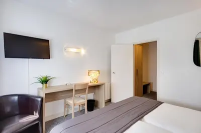 Un ou plusieurs lits dans un hébergement de l'établissement Brit Hotel le Cygne