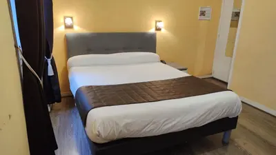 Un ou plusieurs lits dans un hébergement de l'établissement Hotel Angleterre