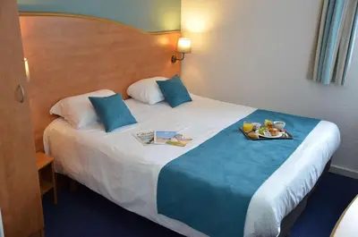 Un ou plusieurs lits dans un hébergement de l'établissement BRIT HOTEL Caen Hérouville