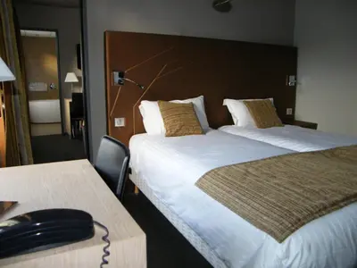 Un ou plusieurs lits dans un hébergement de l'établissement CIT'HOTEL Saint-Pierre