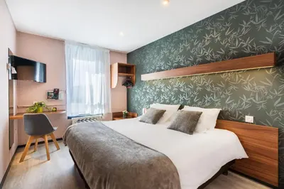 Un ou plusieurs lits dans un hébergement de l'établissement Logis Hôtel Restaurant Le Sainte Mère