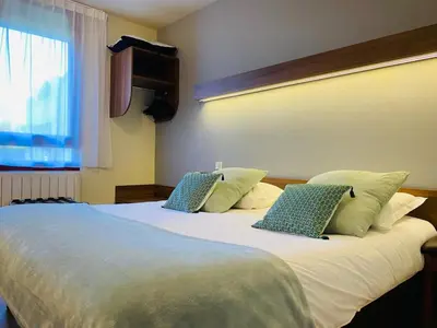 Un ou plusieurs lits dans un hébergement de l'établissement Logis Hôtel Restaurant Le Sainte Mère