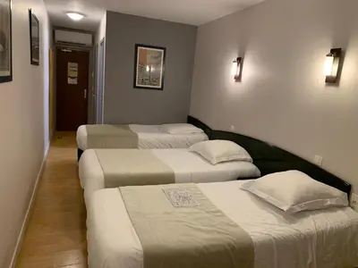 Un ou plusieurs lits dans un hébergement de l'établissement Hôtel Le Bayeux