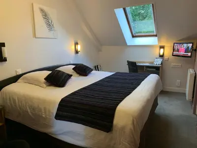 Un ou plusieurs lits dans un hébergement de l'établissement Hôtel Le Bayeux