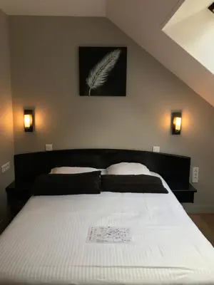 Un ou plusieurs lits dans un hébergement de l'établissement Hôtel Le Bayeux