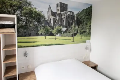 Un ou plusieurs lits dans un hébergement de l'établissement Brit Hotel Confort Saint-Lô