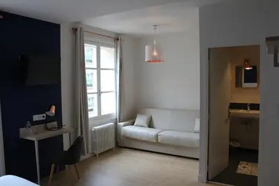 Télévision ou salle de divertissement dans l'établissement Hôtel La Fontaine Caen Centre
