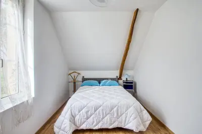 Un ou plusieurs lits dans un hébergement de l'établissement Maison charmante à Saint-Marcouf avec jardin.