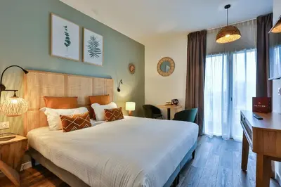 Un ou plusieurs lits dans un hébergement de l'établissement Hôtel & Spa FACE À LA MER