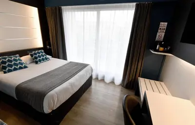 Un ou plusieurs lits dans un hébergement de l'établissement Hôtel Des Quatrans