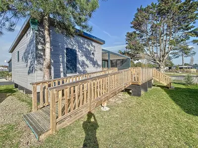 Jardin de l'établissement Chalet de standing à Jullouville - 6 couchages, piscine chauffée, proche plage et commerces, Wi-Fi gratuit - FR-1-361-449