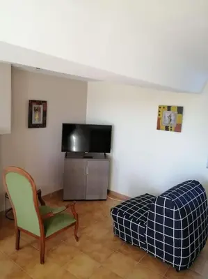 Télévision ou salle de divertissement dans l'établissement Charmante petite maison de vacances