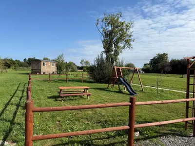 Aire de jeux pour enfants de l'établissement Domaine de la Ville Chérel, maison en pierre